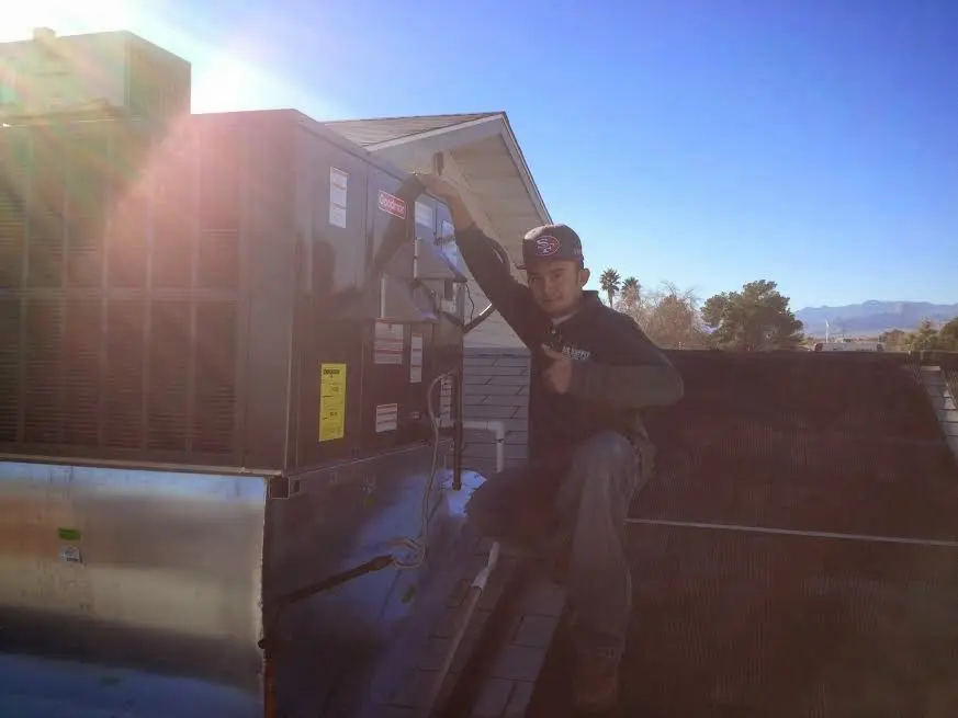 HVAC technician performing HVAC Inspection on a rooftop unit in Busti